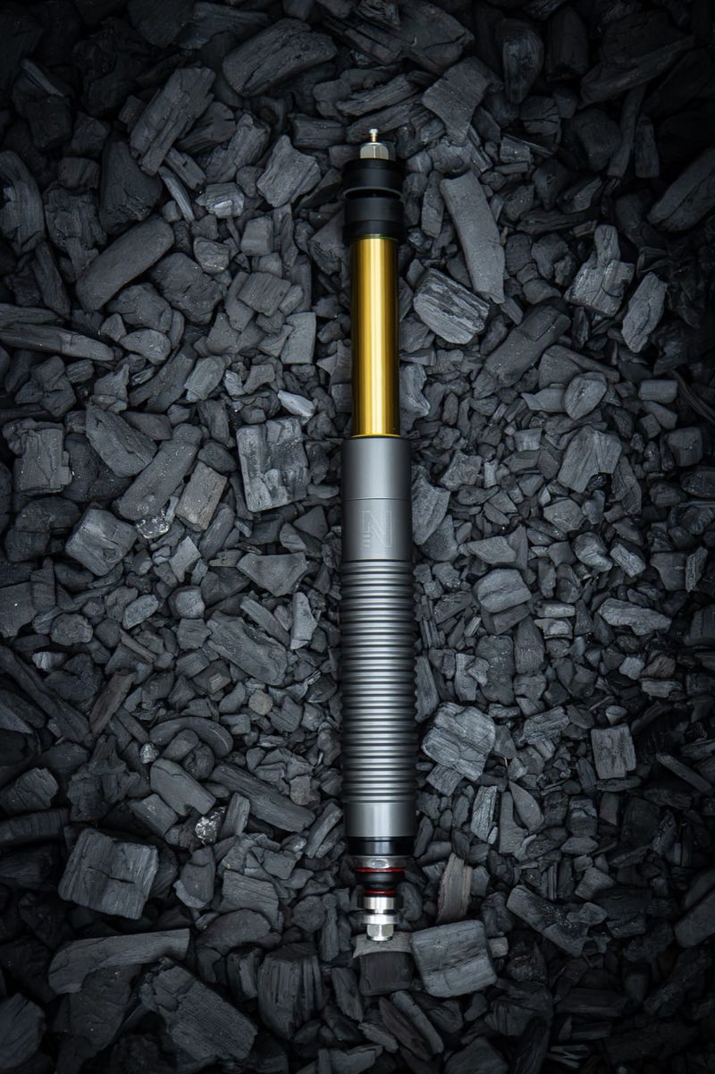 Erebus oleo-pneumatic suspension unit on a dark background